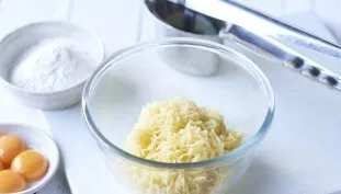 Grate the potatoes on a fine grater.