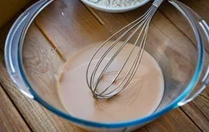 In a bowl, rub the yeast with your fingers, add sugar and warm water. Mix all these ingredients with a whisk until completely dissolved.