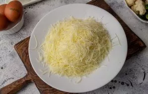 Grate 150 grams of cheese on a fine grater.