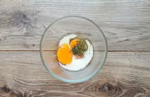 Beat the eggs in a bowl, pour in the milk and add the herbs. Mix everything with a fork until smooth.