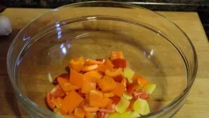 And at the same time, you can prepare vegetables. Peel the peppers, chop them and place them in a deep salad bowl.