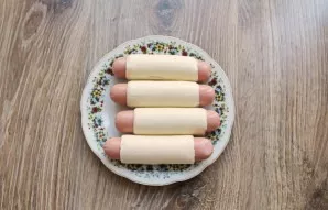 Peel the sausages and cheese. Wrap the cheese around the sausage, pressing firmly to hold.