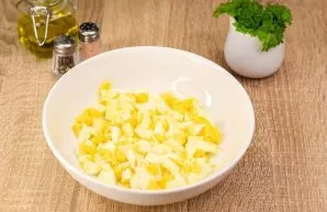 Boil the eggs. Cool and peel. Cut the eggs into small cubes and put them in a salad bowl.