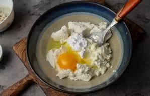 To prepare the dough, put soft cottage cheese in a bowl, add salt, sweetener and egg. Mix everything until smooth.
