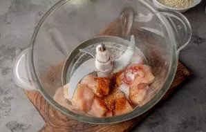 Cut the chicken fillet into pieces, put in a chopper bowl, add spices.