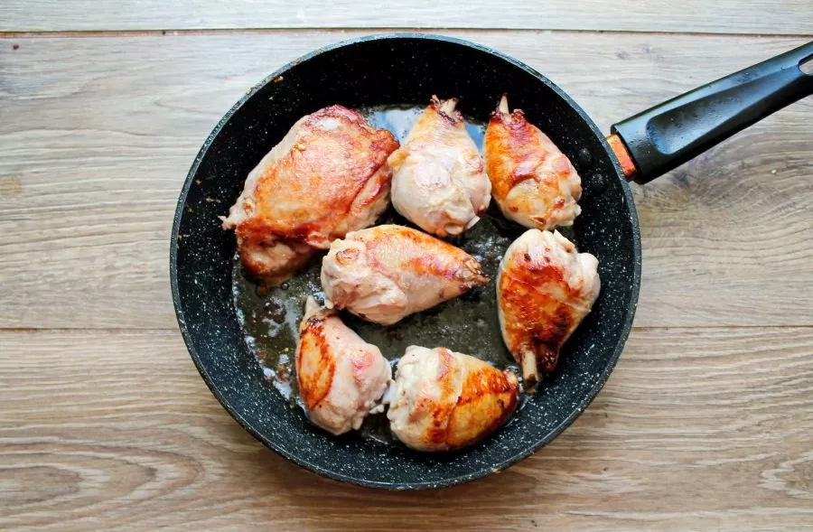 Cut the chicken into portions, wash and dry. Melt the butter in a pan and fry the chicken on all sides over high heat until golden brown.