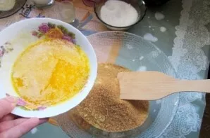Melt the butter and mix with cookie crumbs and 2 tablespoons of sugar. Mix into a homogeneous mass.