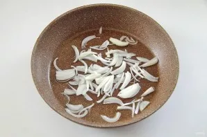 Cut the onion into rings or plushes, put in a pan and pour vegetable oil.