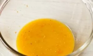 Lets make a marinade. Pour orange juice into a bowl, add mustard and 1 orange zest.