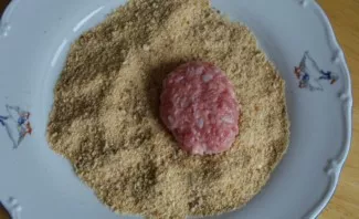 With wet hands we form cutlets. Roll them in breadcrumbs.