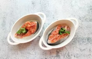 Divide the salmon into two parts, season with salt and pepper. Put the fish in baking dishes and put a sprig of parsley in it.
