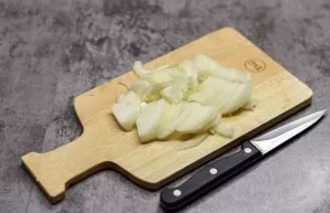 Peel the onion and cut into quarter rings. At this time, heat the stove and put the pan on the fire, add a little oil.