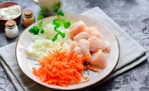 Grate the carrots on a medium grater, cut the onion into cubes. Wash and dry the fillet, cut into small pieces.
