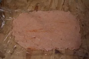 Spread cling film on the table. Lay out the mince. Align it into a rectangle so that there are no holes left.