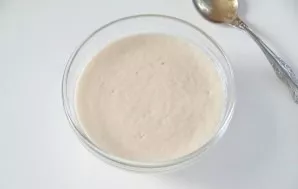 Start with making pizza dough. To do this, add yeast and sugar to warm water. Stir and leave for 10-15 minutes until the yeast rises.