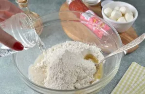 Sift the flour into a deep bowl, add sugar, salt, oil and yeast, pour warm water.