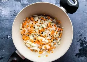 Rinse the carrots under running water and grate. Peel the onion and chop finely. In a well-heated pan with vegetable oil, fry the vegetab...