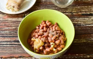 Put the beans in a bowl. Add salt, sugar and mustard. There, squeeze a clove of garlic through a press.