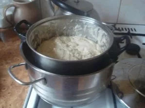 Pour more hot water into the pot, put the pot with the dough in it and leave for 20 minutes for the dough to rise.