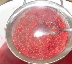 Crush the still hot berries through a sieve directly into the same pot. Pour sugar here, cook over low heat.
