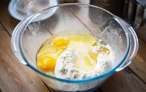First, prepare the dough. Sift all the flour into a large bowl, add salt, beat the eggs and pour in the olive oil.