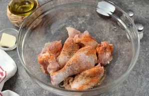 Cut the chicken into large pieces, put it in a deep bowl, add spices and aromatic dried herbs, add oil.