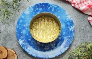 Place a serving ring on a serving plate. Grate the boiled potatoes on a coarse grater, put on the inside of the ring and grease with a ma...