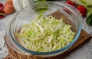 Finely chop the Peking cabbage, using only the upper thin leaflets. Put the chopped cabbage in a salad bowl.