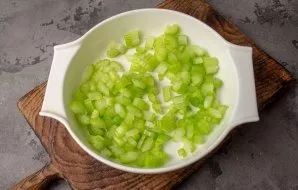 Rinse the celery stalks, dry. Cut into small pieces. Put in a salad bowl.