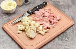 Cut the cooked chicken fillet into small pieces, and also cut the ham into small pieces.