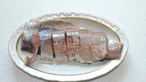 Peel the herring, carefully separate the fillet and cut into small slices.