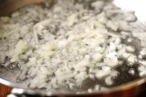 Add some vegetable oil to the pan and heat it. Cut the peeled onion into small cubes and fry for a couple of minutes over medium heat.