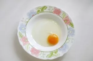 Break the egg into the plate.