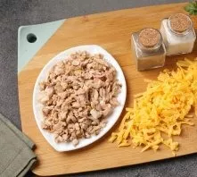 Separate the chicken fillet from the bones and cut into small pieces. Grate the cheese on a coarse grater.