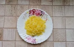 Wash the potatoes, boil in salted water. Cool, peel and grate.