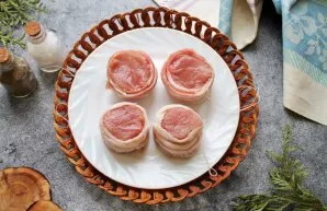 Wash the pork tenderloin, dry and remove all the films. Cut transversely into hockeys 4-5 centimeters thick. Wrap each piece with bacon a...