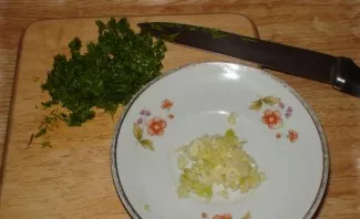 Press the garlic through a press or chop it with a knife. We wash the greens and chop them finely.