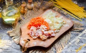Finely chop the bacon, peel the vegetables. Grate the carrots with shavings, cut the onion into small cubes.