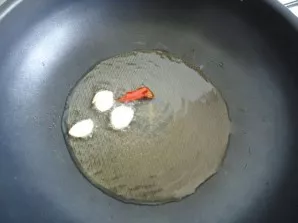 In well-heated oil, fry garlic and chilli.