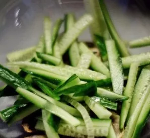 Cut cucumbers into thin strips.