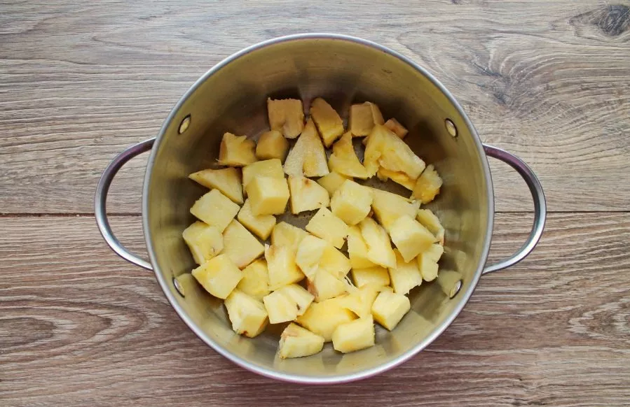 Peel the pineapple, cut it into pieces and put it in a pot.