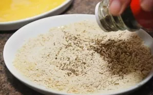 Pour breadcrumbs into the same flat plate. Mix them with spices.