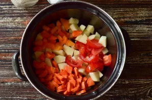 Cut potatoes, carrots, onions, bell pepper into cubes, fresh tomatoes into slices.