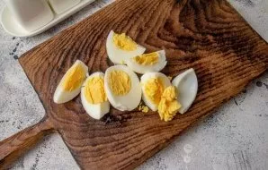 Boil the eggs, cool. Strain and cut into pieces.