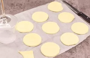 Thaw the puff pastry. Using a glass, cut out small circles. Transfer the dough to a baking sheet and bake for 20 minutes.