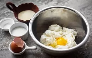 Put cottage cheese in a bowl, crush with a fork, beat an egg.