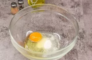 Break an egg into a deep bowl, add sugar and a pinch of salt.