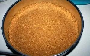 Mix the butter and crumbs well. Line the cake pan with parchment paper (cut to the diameter of the pan). Put the cookie crumbs in the mol...