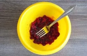 Prepare the filling. Mix fresh cranberries with sugar. Mash with a fork.