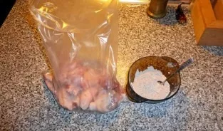 Transfer the wings to the bag. Pour in a mixture of flour and spices. Mix thoroughly so that the wings are covered with flour.